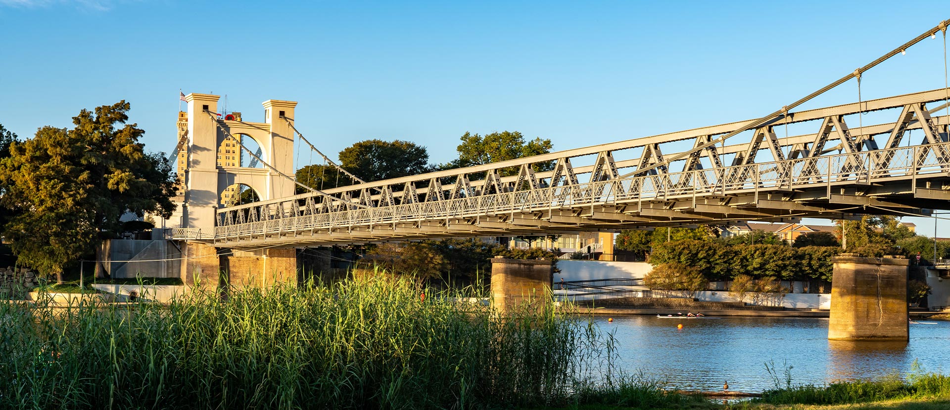 The image shows a scenic view of a bridge over a body of water, with a clear sky and calm water visible.